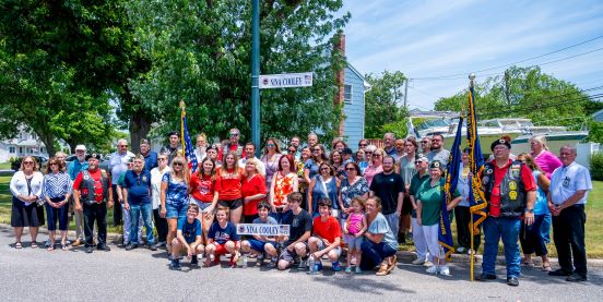large group shot under new sign, members of community, family and local leaders