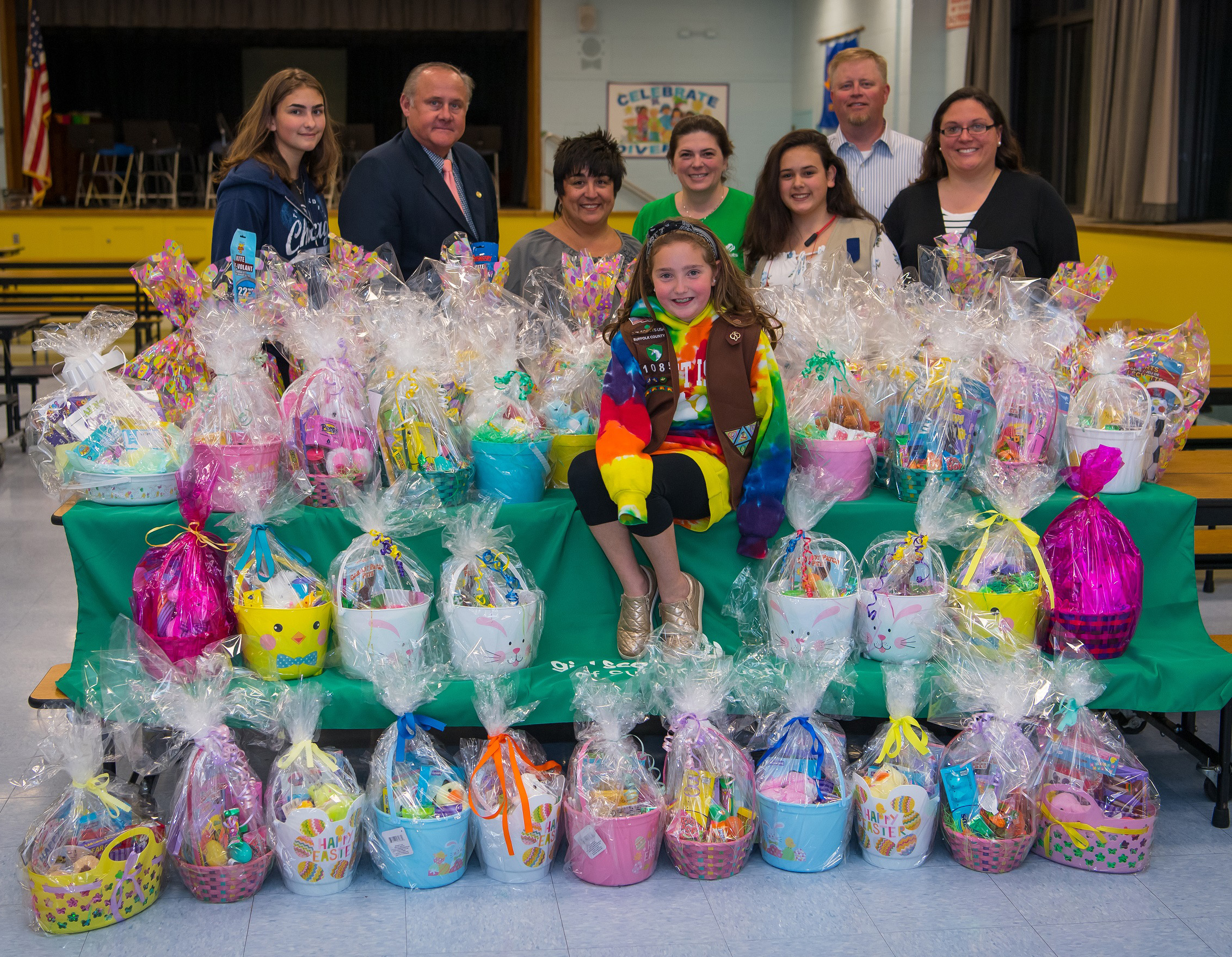 girl scouts and representatives stand easter baskets