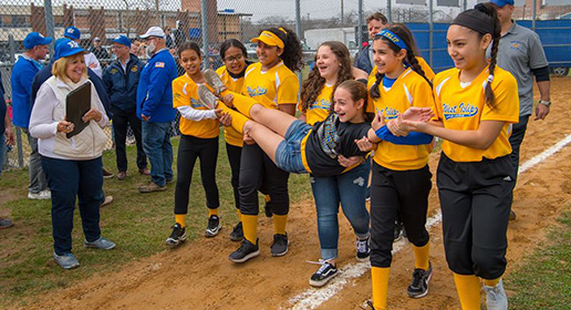 West Islip girls on the softball team carry one of their teammates as Supervisor Carpenter looks on