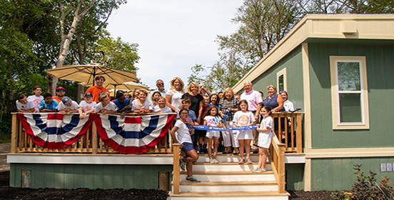 Islip Town Officials stand with campers of Camp Byron on the Lake at the Ribbon Cutting of the new Camp Trailer.