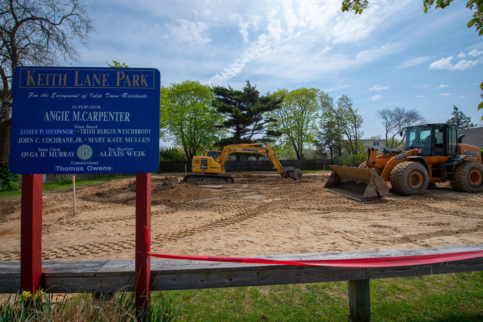 Keith Avenue Park sign in the foreground of the photo, with heavy machinary behind the sign working to clear the land for a new playground to be installed