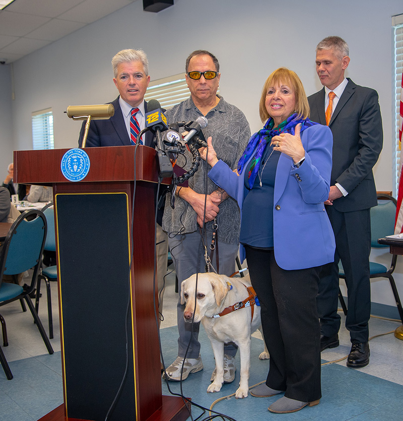 Supervisor Carpenter stands with County Executive Steve Bellone and a resident who uses the services provided by the Town, that help him live a normal life after loosing his eyesight.