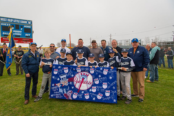 Baseball players hold a banner as coaches and Councilmen James P. O'Connor and John Cochrane join them with County Legislator Steve Flotteran