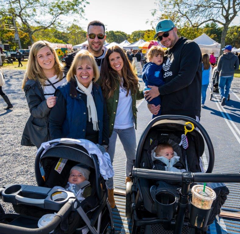 Supervisor Carpenter poses with 2 families with strollers at the 2019 apple fest.