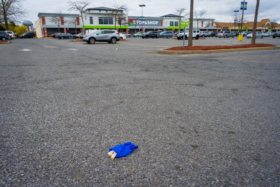 disposed blue glove in the supermarket parking lot