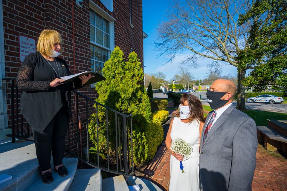 Supervisor Carpenter Officiates the wedding at the top of the Town Hall Steps while the bride and groom stand at the bottom, 6 feet from her