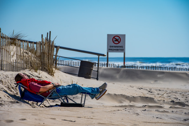 man on lounge chair at beach