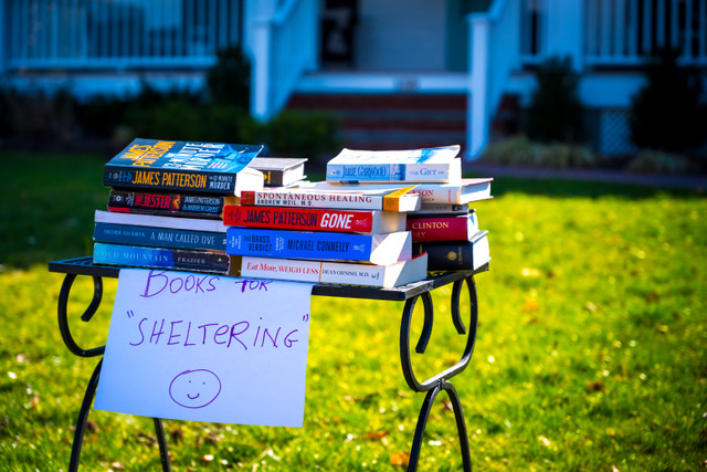 Books on a table for public use outside of a home