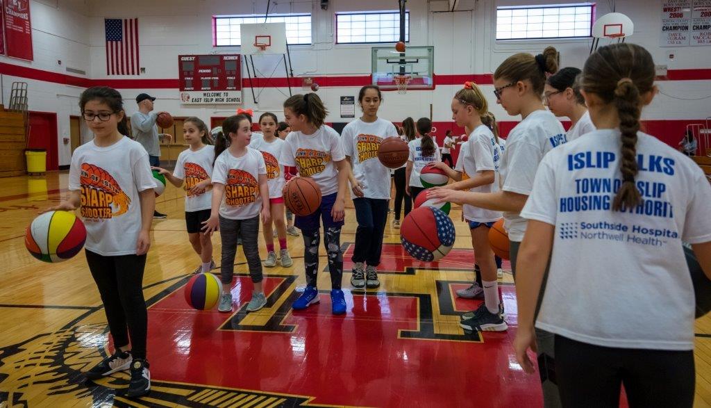 A group of young lady ballers gathered at the freethrow line, ready to take a shot.
