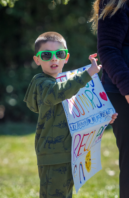 young boy holds sign for teachers