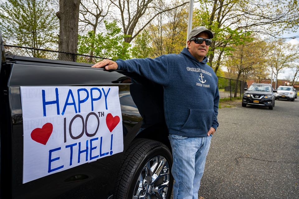 Happy 100th Birthday sign hanging on pickup truck