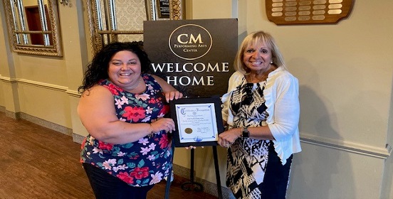 Supervisor Carpenter stands with Alyse Arpino, Executive Director of CM Performing Arts. The supervisor presents Alyse with a certificate to commemorate the re-opening of the performing arts center since the COVID-19 pandemic began.