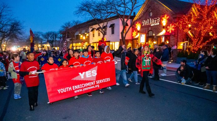 Youth Enrichment Services marches in the parade all in red