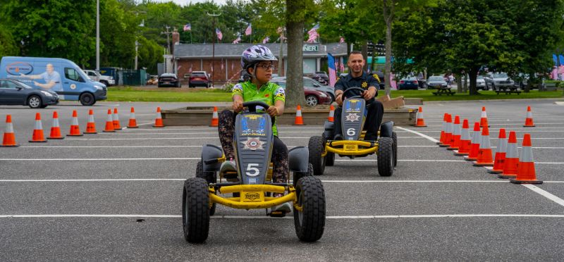 Rodeo attendee and Officer on go-kart like pedal bikes