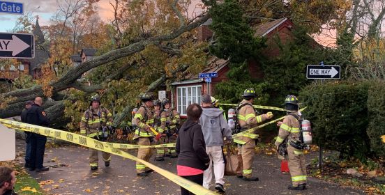 Tree on top of house while fire rescue assess damage