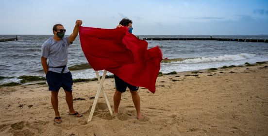 life guards at blowing red swim flags
