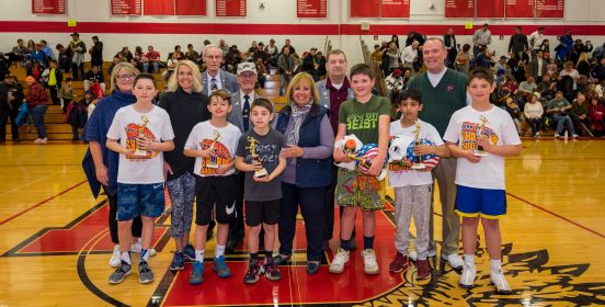 Supervisor Carpenter, Town Board Members O'Connor and Mullen, along with Deputy DPW Commissioner Whalberg stand for a photo mid court with participating sharpshooters and event officials.