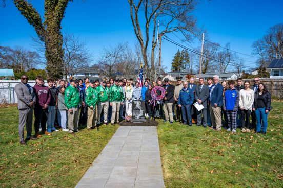 Group photo of veterans, dignitaries, and students
