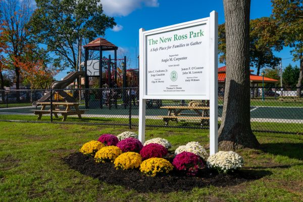 Sign of the New Ross Park with the new playground and benches in the background