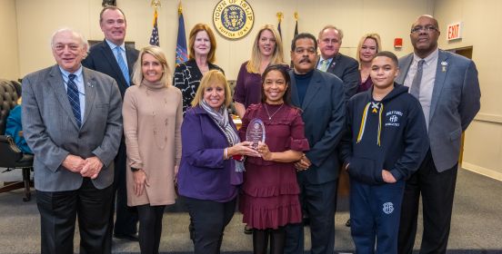 An image of the Islip Town Board and Sharon Dungee posing for a photo in the Islip Board Room, having recognized her at the Islip Black History Celebration.