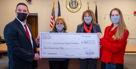 supervisor and check recepients hold oversized check
