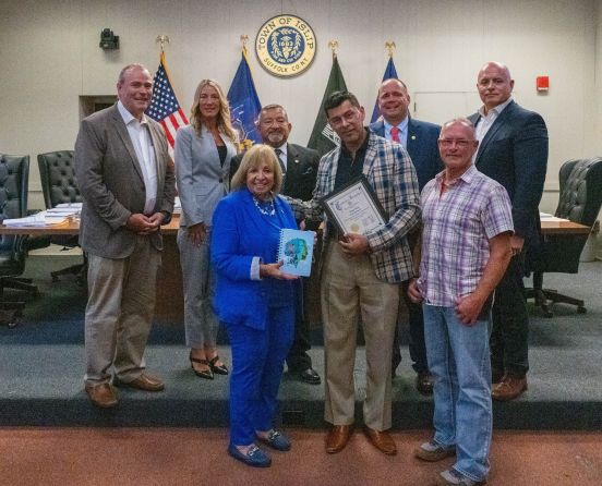 Town board in group photo with artist