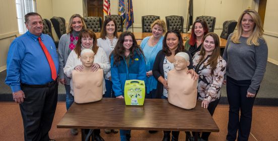Receiver of Taxes Weik and Personnel Director Abbate pose for a photo with staff and training dummies in the Town Board Room.