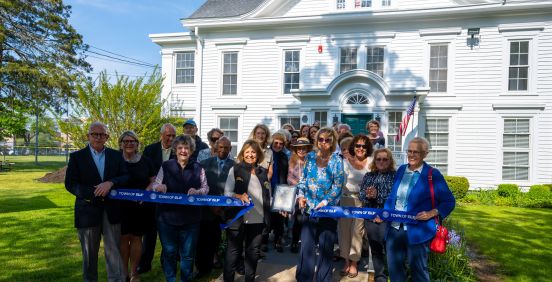 group photo cutting the ribbon on the Gillette House