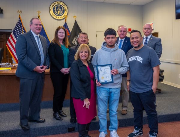 Supervisor Carpenter and the Town Board stand with Brentwood HS Student Edwin Yanes and his Teacher Mr. Salgado as he was honored by the Town Board for his civic engagement