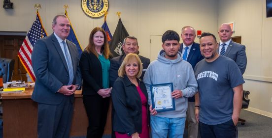 Supervisor Carpenter and the Town Board stand with Brentwood HS Student Edwin Yanes and his Teacher Mr. Salgado as he was honored by the Town Board for his civic engagement