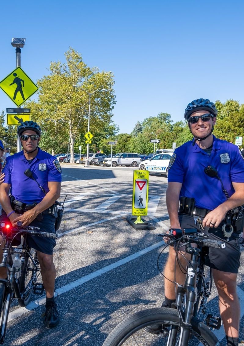 park rangers bike patrol in purple shirts